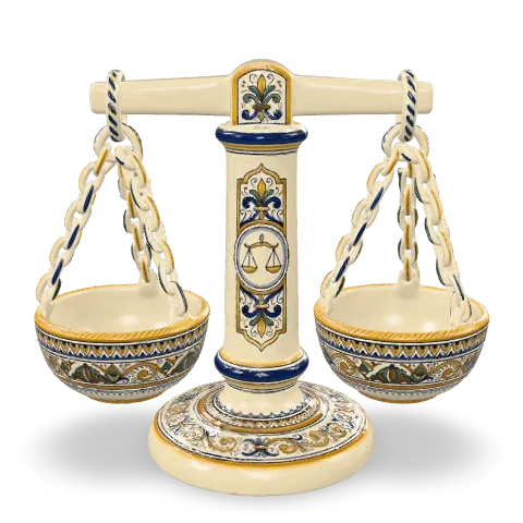 Bilancia in maiolica: una colonna bianca dipinta che regge un braccio con due piatti tondi appesi a catenelle, su una base tonda decorata in cobalto.