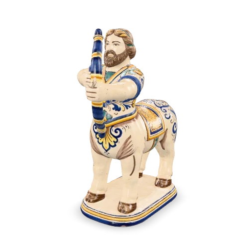 Arciere in maiolica con il busto d’uomo su un corpo di cavallo, che tende un arco corto: figura popolare bianca decorata in cobalto e zafferano.